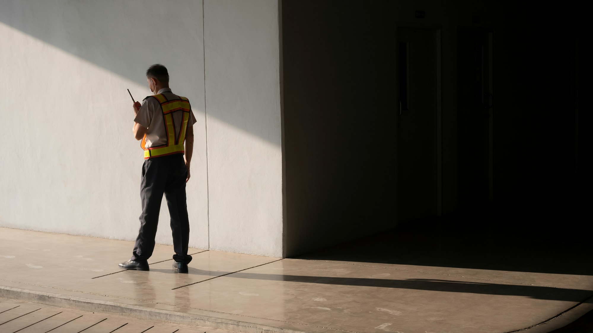 Security guard using walkie talkie while working in underground of parking garage